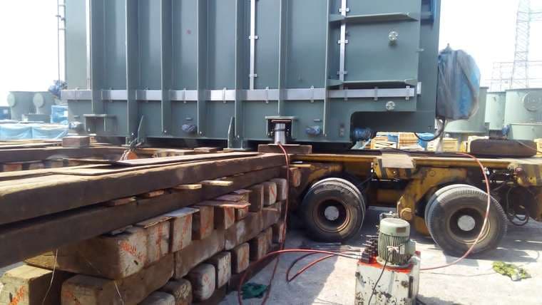 Transformer being transferred onto a hydraulic axle trailer with a hydraulic power pack alongside.